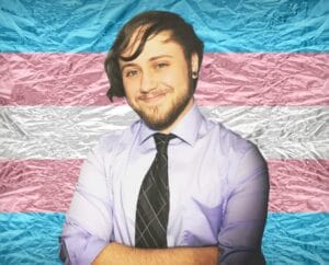 Quinten Foster, MS standing in front of a trans flag